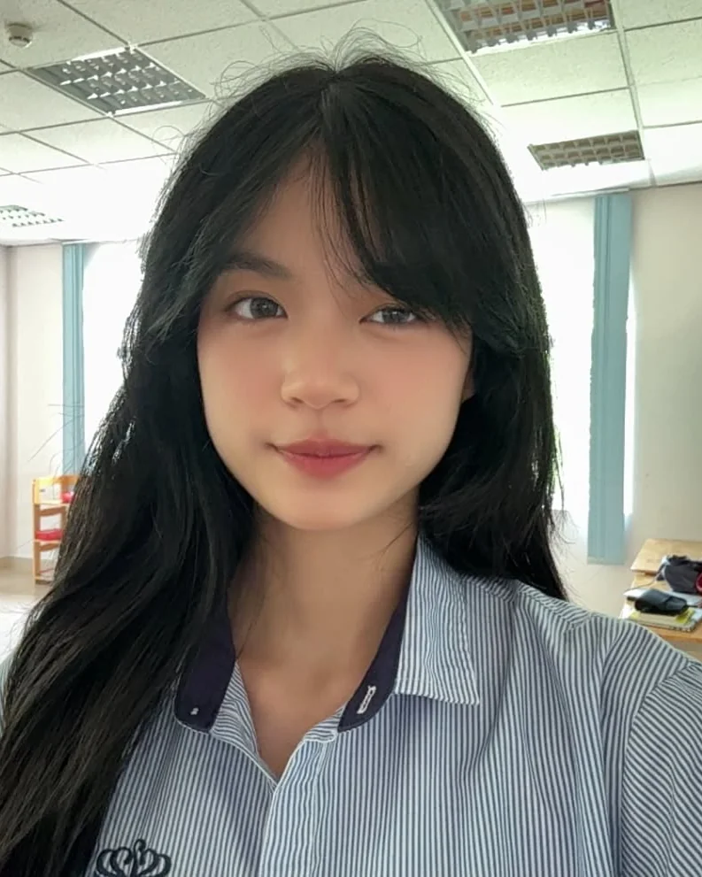 Portrait of Khanh Chi in her BVIS school shirt, in a classroom